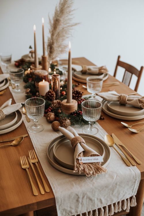 A boho-inspired Christmas dining table styled with a neutral fabric runner featuring tassel edges, earthy ceramic dinnerware, and simple glassware. The centerpiece combines pampas stalks, candles, pinecones, and wooden accents, creating a warm and inviting atmosphere. Handmade macrame napkin rings and small personalized place cards add a whimsical, DIY touch. Layered textures, muted tones, and subtle metallic details enhance the table without overwhelming guests, resulting in a cozy yet elegant bohemian holiday setting perfect for gatherings.Keywords/Focusboho christmas table settingsbohemian holiday dining decorcozy christmas tablescape ideasAlt TagBoho Christmas table setting with pampas centerpiece, candles, pinecones, neutral tassel runner, handmade napkin rings, and earthy ceramicsImage TitleBoho Christmas Table Settings – Cozy and Elegant Holiday Dining Style