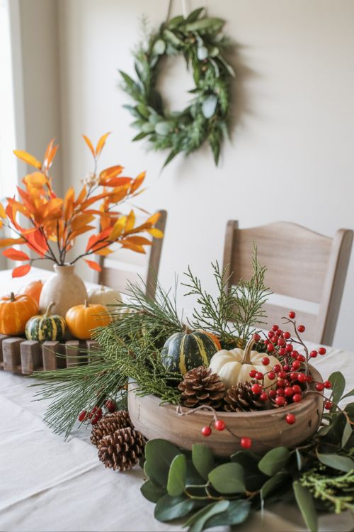 Dining room decor transition showing fall foliage with pumpkins replaced by pinecones, cranberries, and winter greenery for a cozy seasonal update.