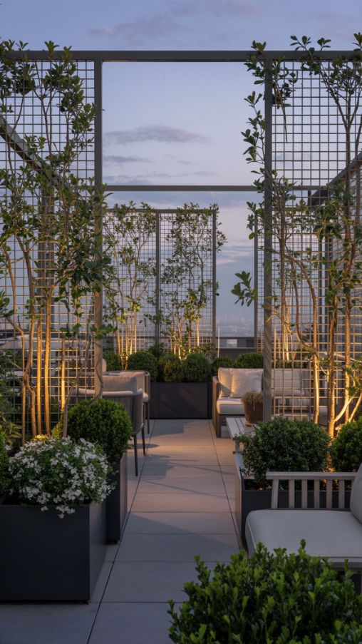 Rooftop terrace with tall planters, climbing plants, and trellises creating a private, cozy outdoor space