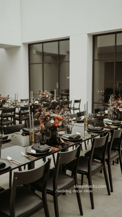 Minimalist wedding reception with black-and-white tables, vibrant floral centerpieces, and metallic accents in an urban venue