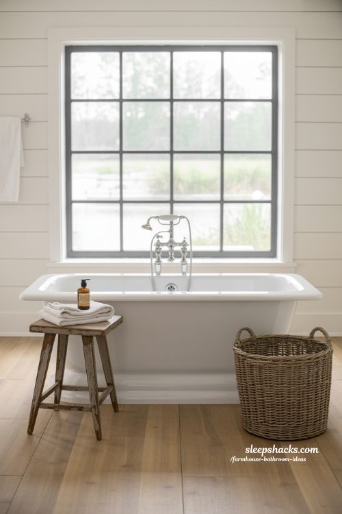 Cozy Farmhouse Bathroom Retreat Featuring a White Freestanding Soaking Tub and Rustic Wood Accents