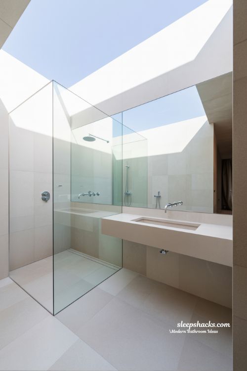 Modern Compact Bathroom with Wall-to-Wall Mirror and Seamless Glass Partition