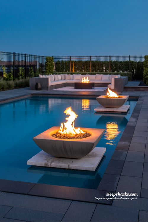 Modern Inground Pool with Integrated Stone Fire Bowls and Ambient Evening Glow
