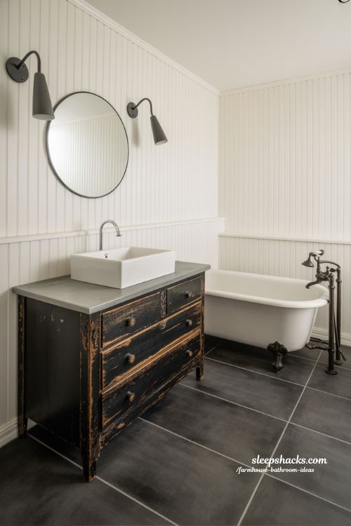 Rustic-Modern Farmhouse Bathroom with Vintage Vanity, Concrete Floor, and Clawfoot Tub