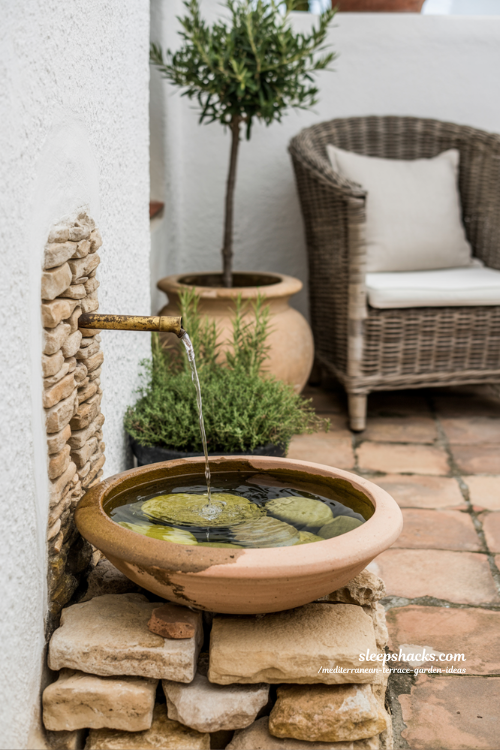 Simple Terracotta Water Feature and Cozy Seating Corner on Mediterranean Terrace