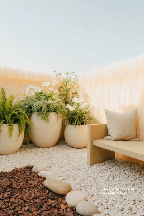 Small backyard color ideas using light shades and white fences to create an open and expansive garden feel