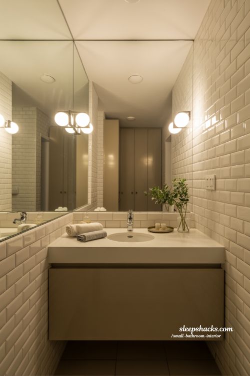 Small bathroom interior ideas with mirrors and warm lighting for bigger brighter spaces