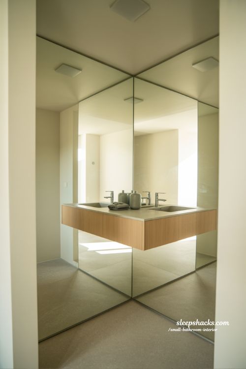 Small bathroom interior with floor to ceiling mirror reflection tricks minimalist modern design making space look bigger and brighter
