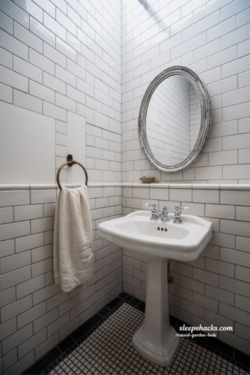 Small vintage bathroom decor with pedestal sink and penny tile floor in sharp focus
