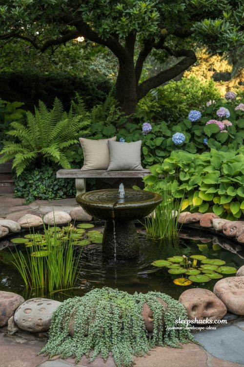 small stone water feature with a bubbling fountain and aquatic plants in a shaded garden corner