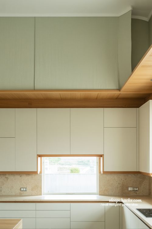 wallpaper and painted above cabinet decor ideas for modern kitchens with subtle textured wall design and minimalist clean aesthetic