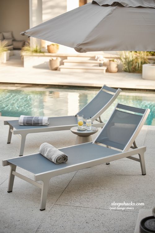 Classic aluminum pool lounge chairs with breathable mesh fabric beside a modern backyard pool 