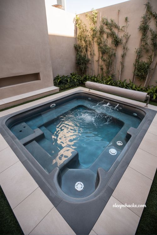 Compact fiberglass spool spa-pool combo in small urban backyard courtyard with modern minimalist spa design and integrated jets and heated water