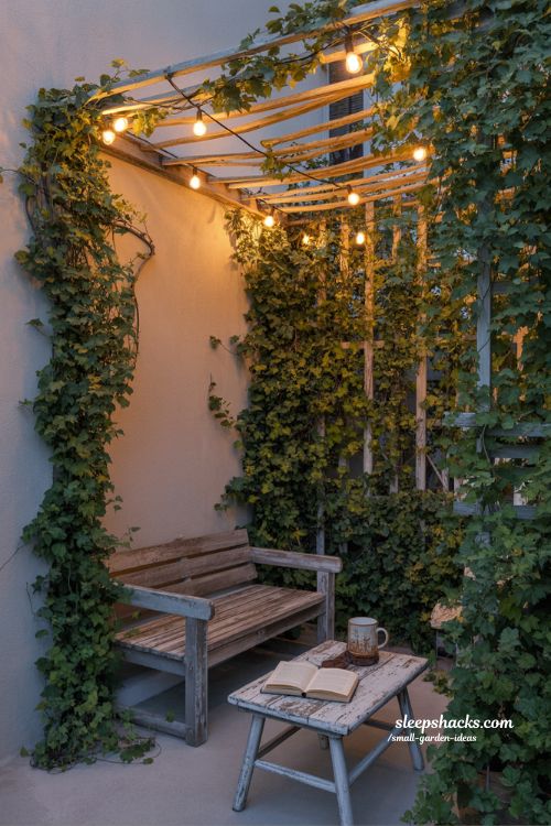 Cozy garden corner ideas with vines and warm string light canopy atmosphere