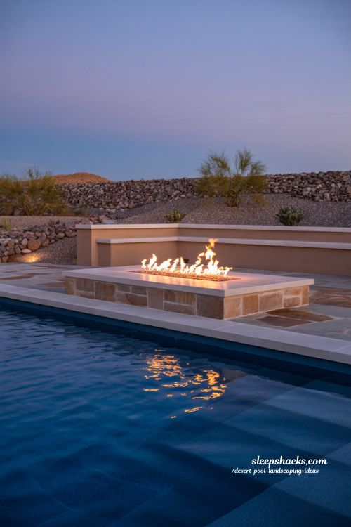 Desert pool with integrated fire pit design at night luxury backyard fire and water landscaping ideas