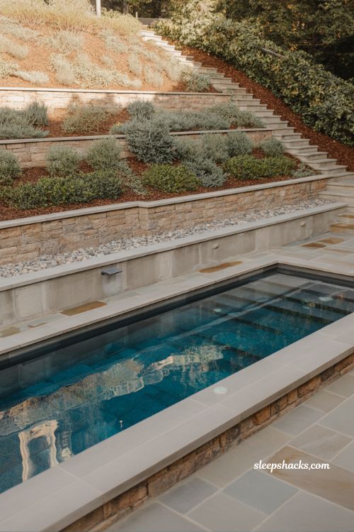 Fiberglass pool on sloped backyard with retaining wall modern landscape design and engineered outdoor living space with tiered backyard structure