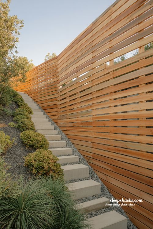 Horizontal wood slat fence ideas for modern sloped backyard with cedar privacy design