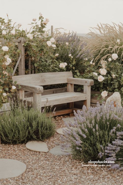 Relaxing coastal cottage garden seating ideas with weathered bench surrounded by lavender and roses