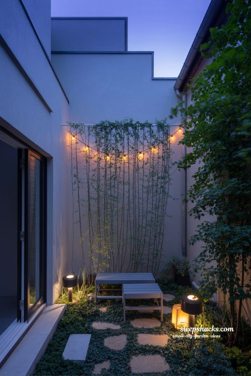 Small city garden ideas with warm evening lighting, string lights and soft glow that transform outdoor spaces at night