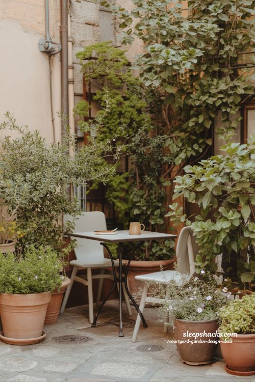 Small courtyard outdoor dining corner with cozy table and surrounding greenery