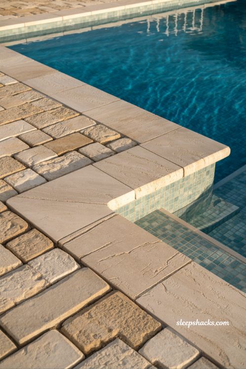 Upgraded travertine coping fiberglass pool with luxury stone edge detailing and modern minimalist backyard patio design