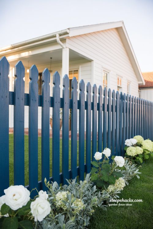 bold colored picket fence curb appeal garden with white flowers and modern cottage exterior