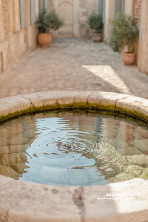 french courtyard garden with stone water feature creating calm movement and reflective peaceful atmosphere