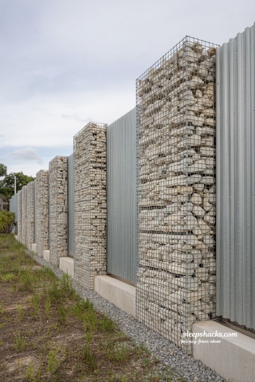 gabion stone cage fence ideas with corrugated metal panels for a modern industrial landscape privacy design