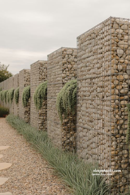 gabion wall garden fence filled with river stones and ornamental grasses modern landscape boundary