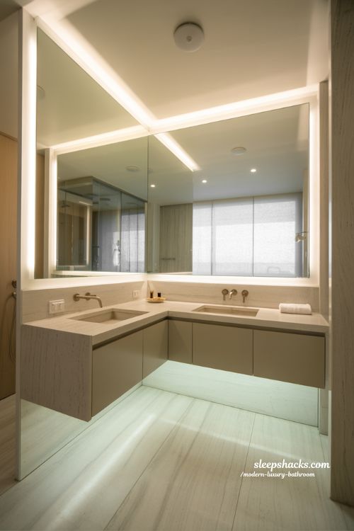 mirror design in modern luxury bathroom with oversized backlit mirror layered lighting and spa inspired minimalist interior 