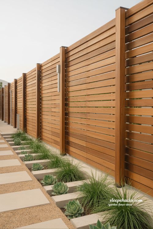 modern horizontal slat privacy fence with minimalist backyard landscaping and ornamental grasses