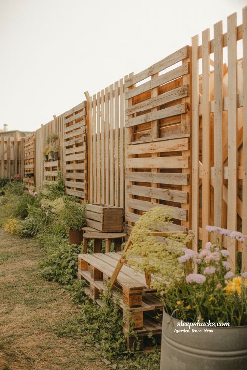 reclaimed wood pallet garden fence with wildflowers in rustic boho backyard design