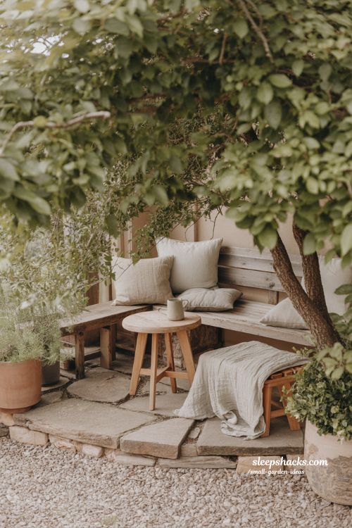 simple garden seating corner with wooden bench under tree for slow summer evening retreat