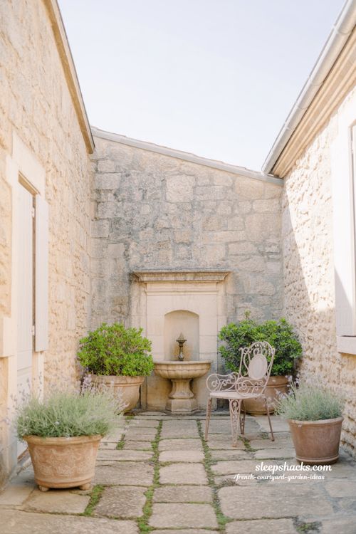 small french courtyard garden design with fountain seating and minimal plants creating complete calm outdoor space