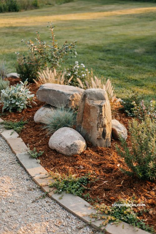 Backyard mulch ideas with large boulders in natural sculptural garden design