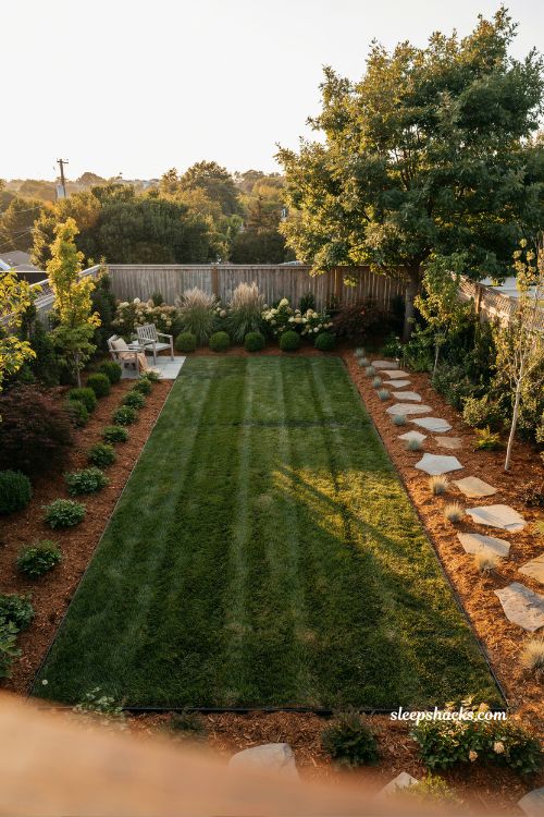 Backyard mulch ideas with wide border landscaping and layered garden design