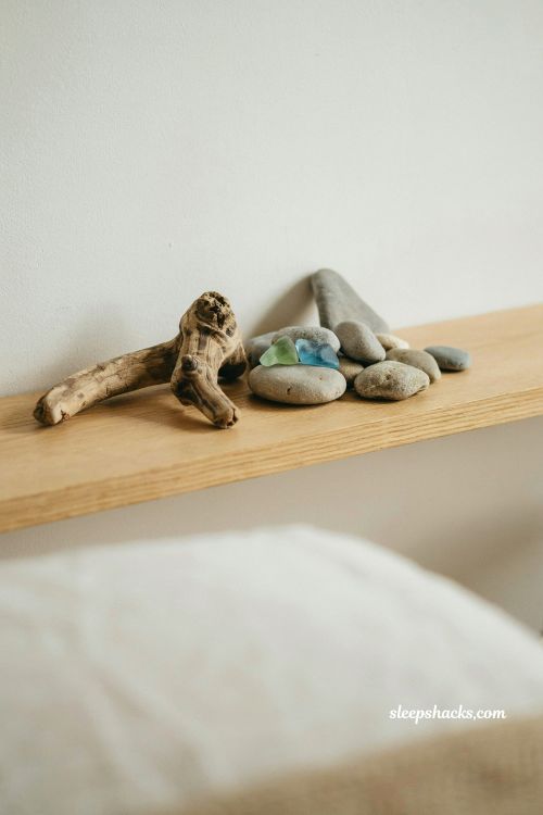 Beach house bedroom shelf with found objects driftwood and sea glass styled like art coastal minimal decor natural collected seaside pieces