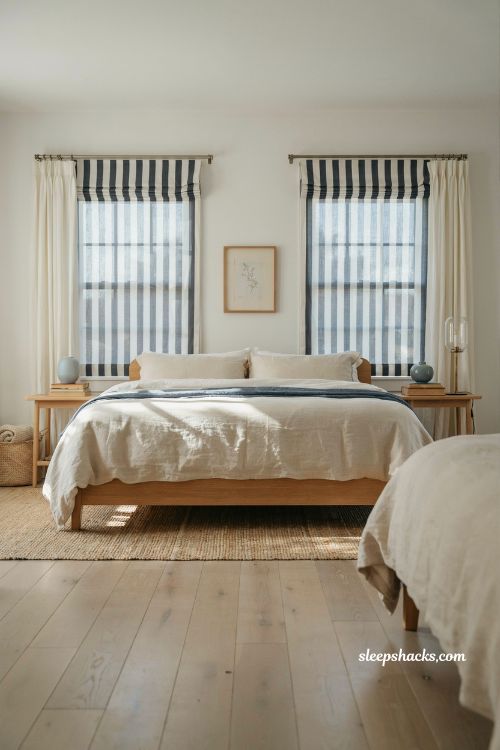 Beach house bedroom with striped Roman shades Cape Cod coastal style navy and white window treatments soft filtered natural light seaside interior