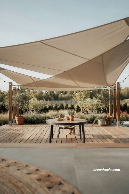 Budget shade sail deck cover with four corner posts and string lights