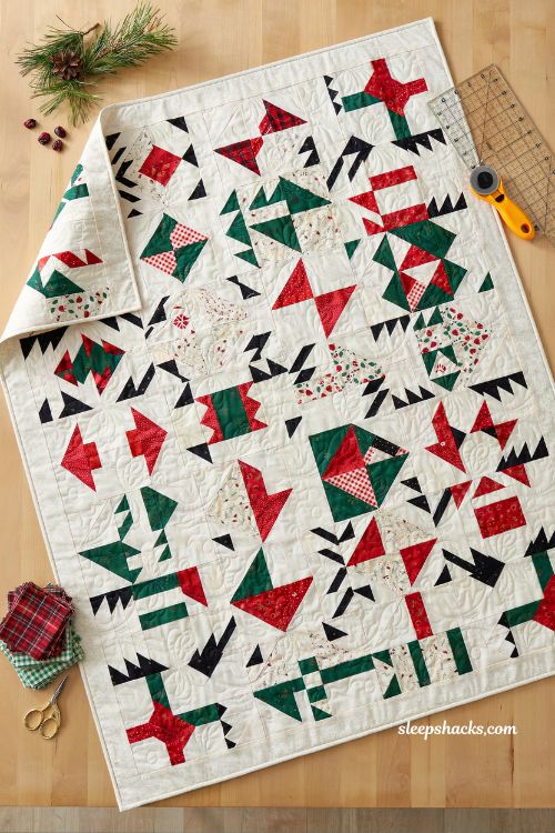 Christmas churn dash block quilt on point layout in red green and cream traditional patchwork design on cozy sewing studio table with classic holiday quilting aesthetic