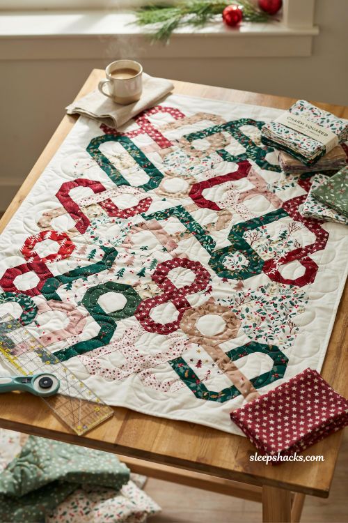 Christmas stars wall hanging quilt with red green and gold star blocks on cream sashing displayed on neutral studio wall with elegant minimalist holiday quilting aesthetic