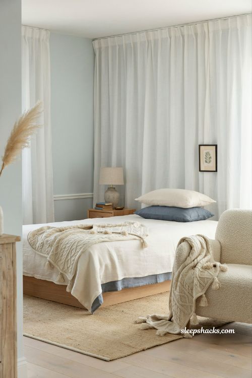 Coastal blue bedroom ideas with nautical rope detail throw blanket and subtle beach house texture styling