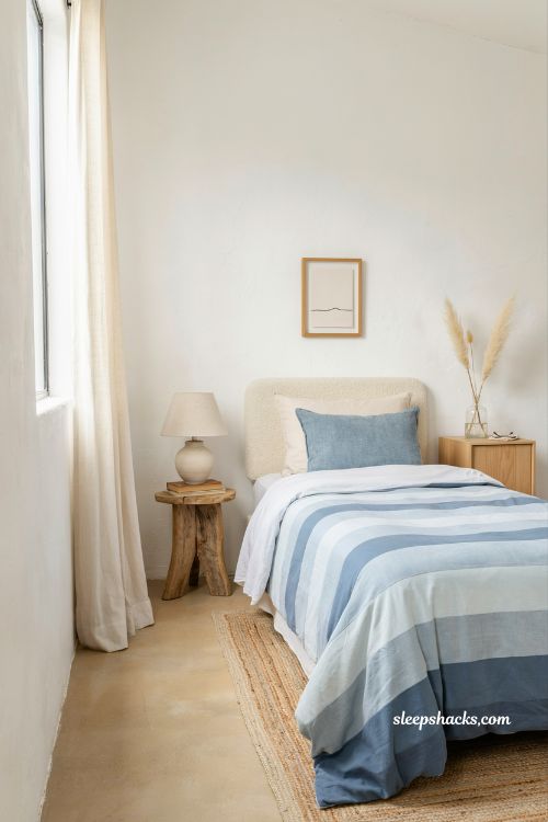 Coastal blue bedroom ideas with striped bedding inspired by ocean waves and calm beach house style