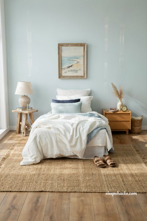Coastal blue bedroom ideas with woven jute rug and warm natural beach house flooring style