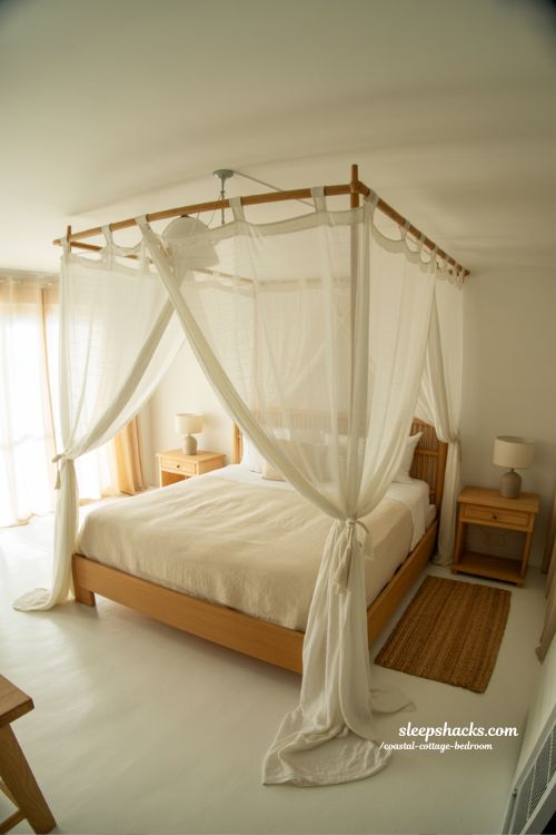 Coastal cottage bedroom with sheer canopy bed white linen gauze drapery and natural wood accents