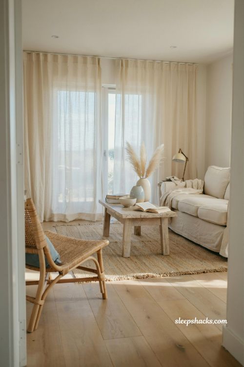 Coastal living room with linen curtains filtering soft natural light and airy beach style