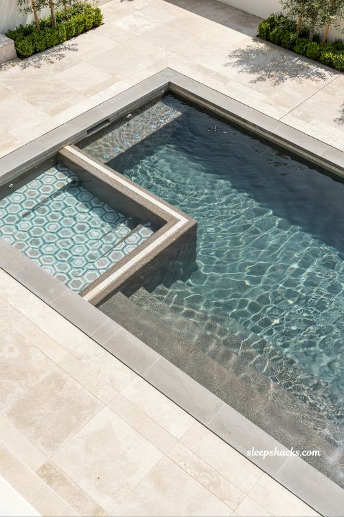 Contemporary backyard pool with geometric tile interior design and dark modern finish creating an artistic luxury outdoor swimming aesthetic