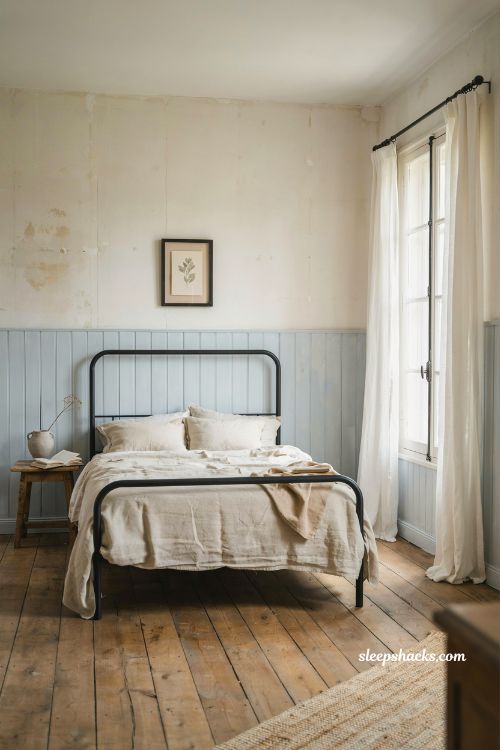 French blue bedroom ideas with icy blue wall paneling flax linen bedding and black iron accents
