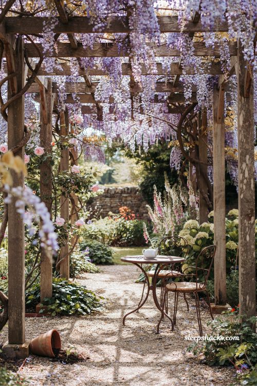 Garden fairytale ideas with a wisteria draped pergola and dappled sunlight seating