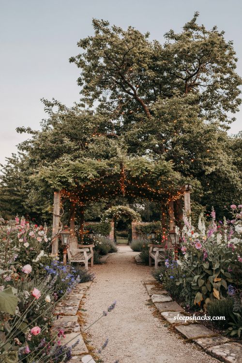 Garden fairytale ideas with soft fairy lights draped through a magical garden canopy